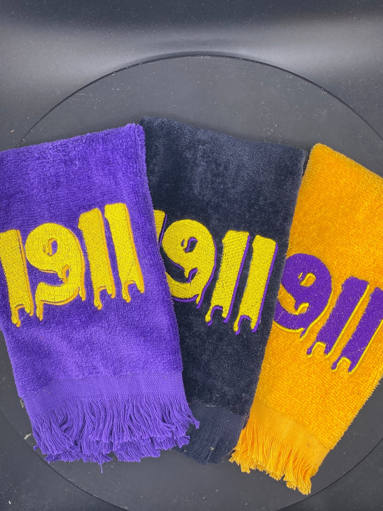 3 1911 Drip Hop Towels in purple, black, and gold representing Omega Psi Phi Fraternity - West & Remount Custom Apparel